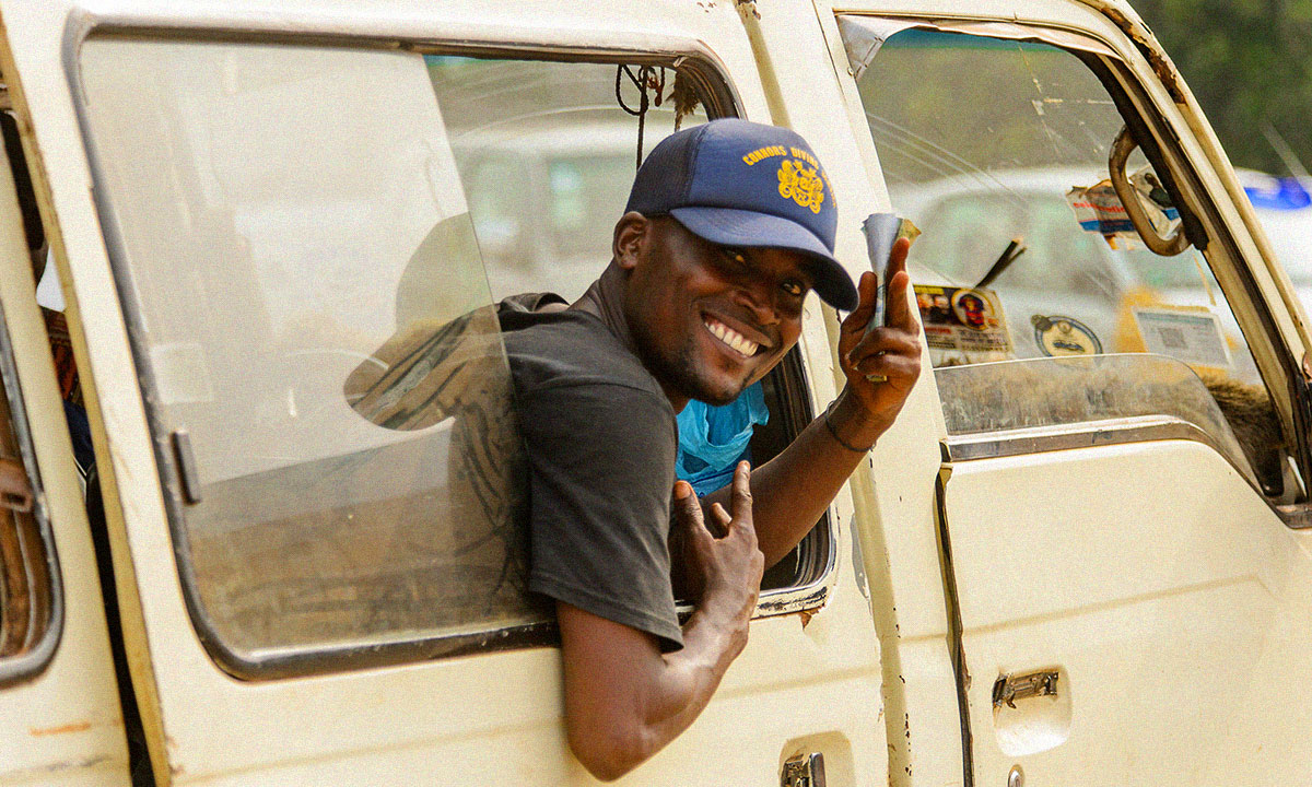 Ghanian man hangs out of a van in Accra